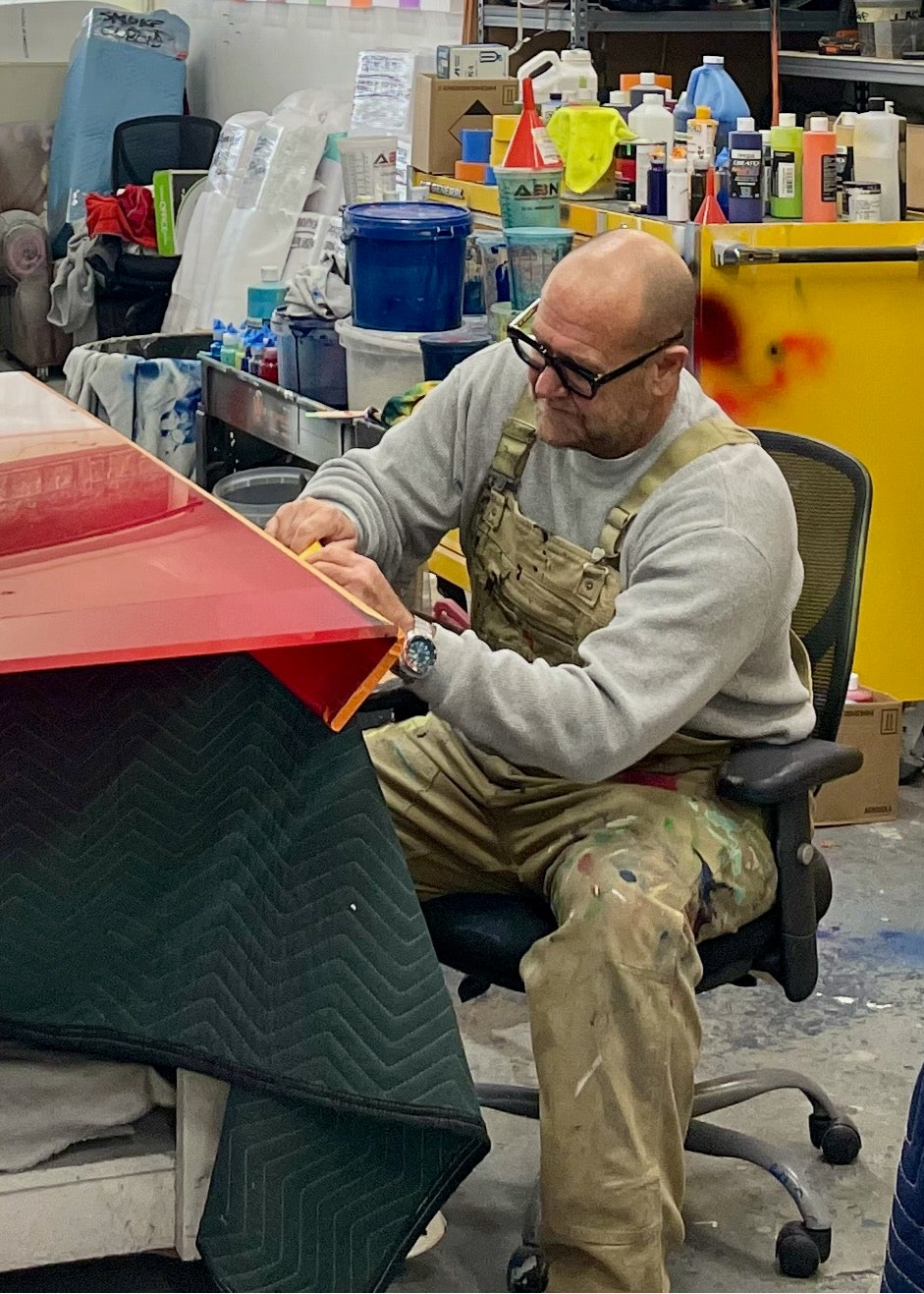 Casper Brindle, artist, in paint stained overalls working on his Veil art pieces in his studio